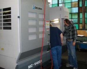 Machine Shop Supervisor Ron Wink preparing the new CNC machine for a production run.
