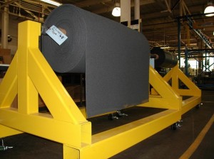 A large rack holds a roll of material