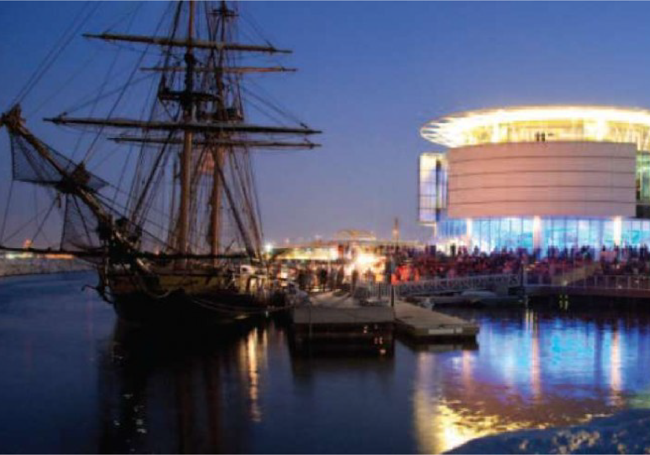 the Denis Sullivan sits in the harbor by the Discovery World Museum at sunset.