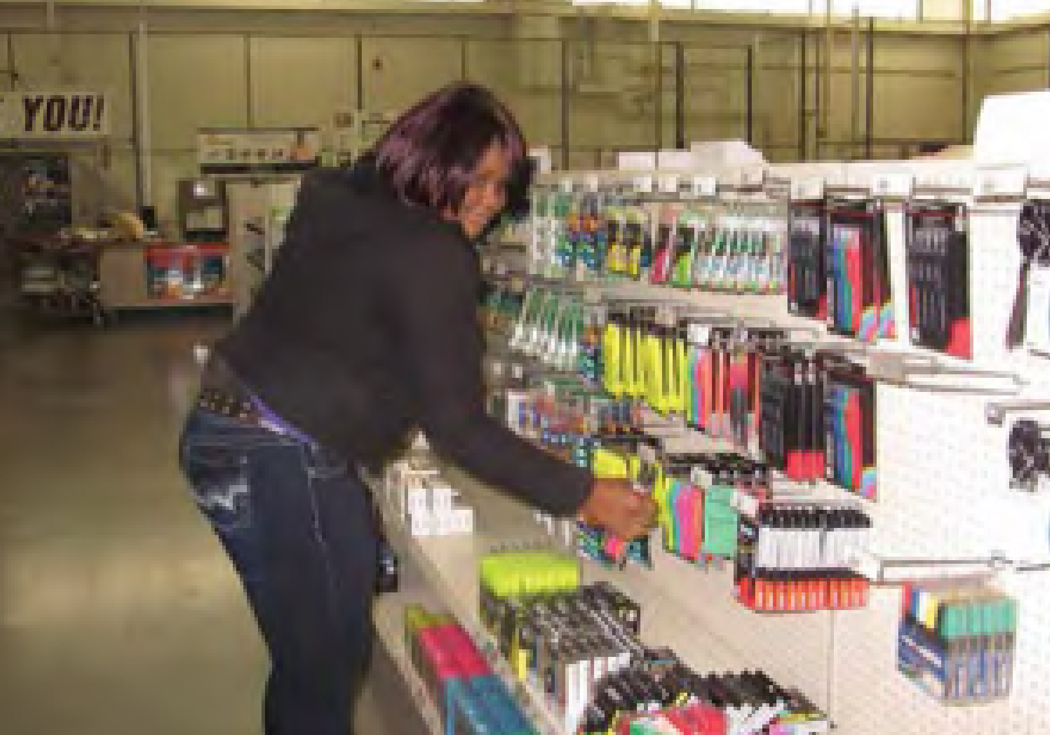 alma restocking office supplies on a shelf