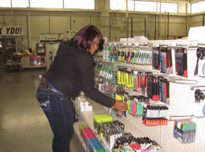 alma restocking office supplies on a shelf