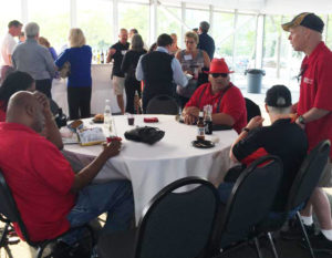 Several Beyond Vision employees sit at a round table with a white tablecloth. They are relaxing and talking.