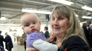 Mary LaPointe is holding her grandchild and smiling.