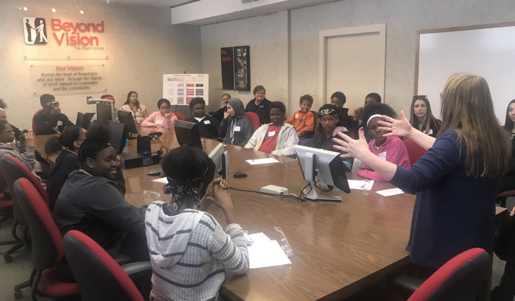 Students sit in a conference room at a large meeting table.