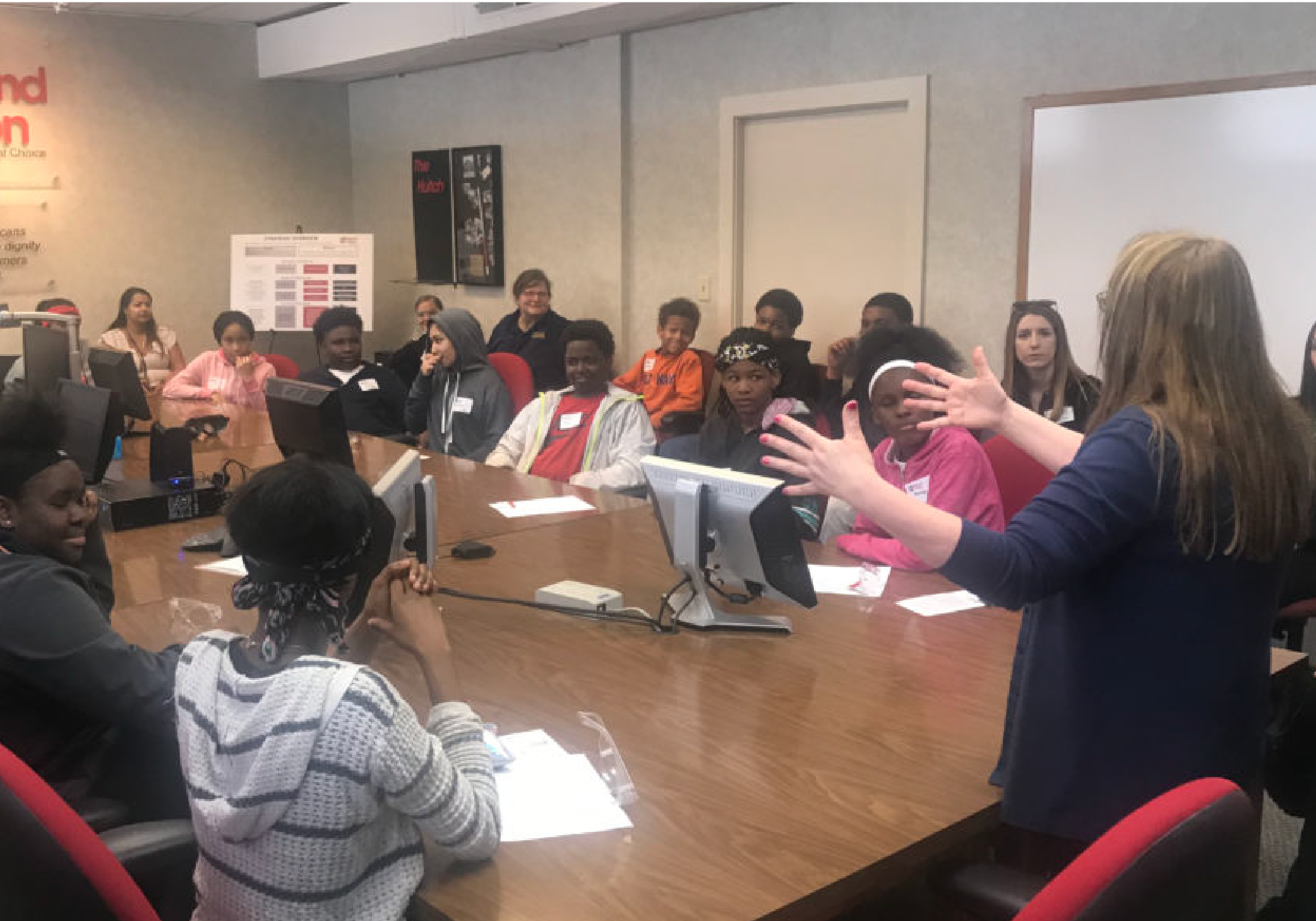 Students sit in a conference room at a large meeting table.