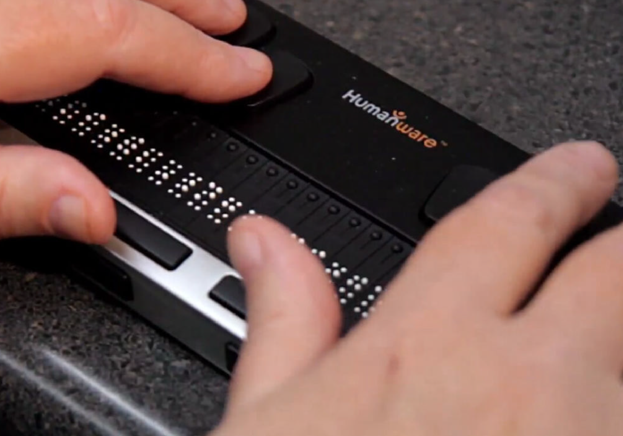 a pair of hands on a braille reader