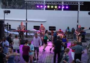 Los Ciegos del Barrio performing in front of a crowd of dancing people