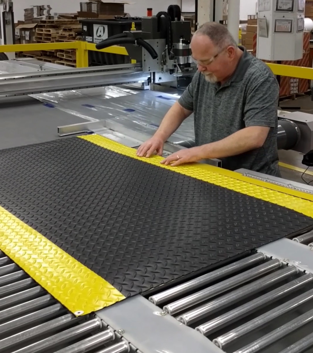 Gene is using a laser cutter to make a mat