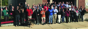 Beyond Vision employees standing in front of the building smiling and waving