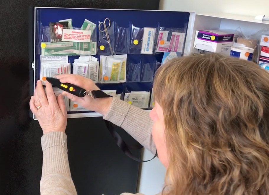 Mary has a first aid kit open and is scanning a packet.