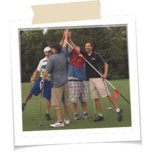 A foursome of golfers high fiving on the green.