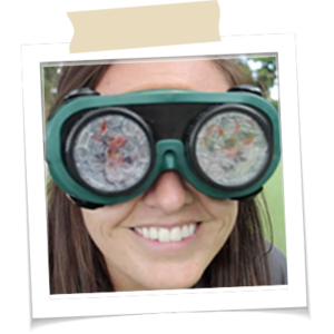 A women smiling while wearing goggles that represents being visual impaired.