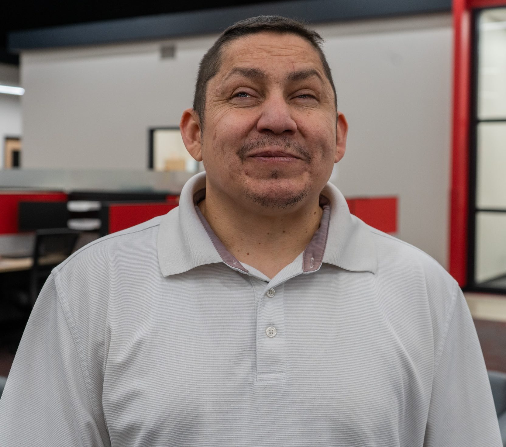 Photos of Tony Creapeau smiling and wearing a white polo in the Beyond Vision open office area.