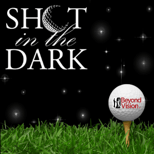 Shot in the Dark. Picture of a golf ball with beyond vision's logo on it sitting on a tee at night.