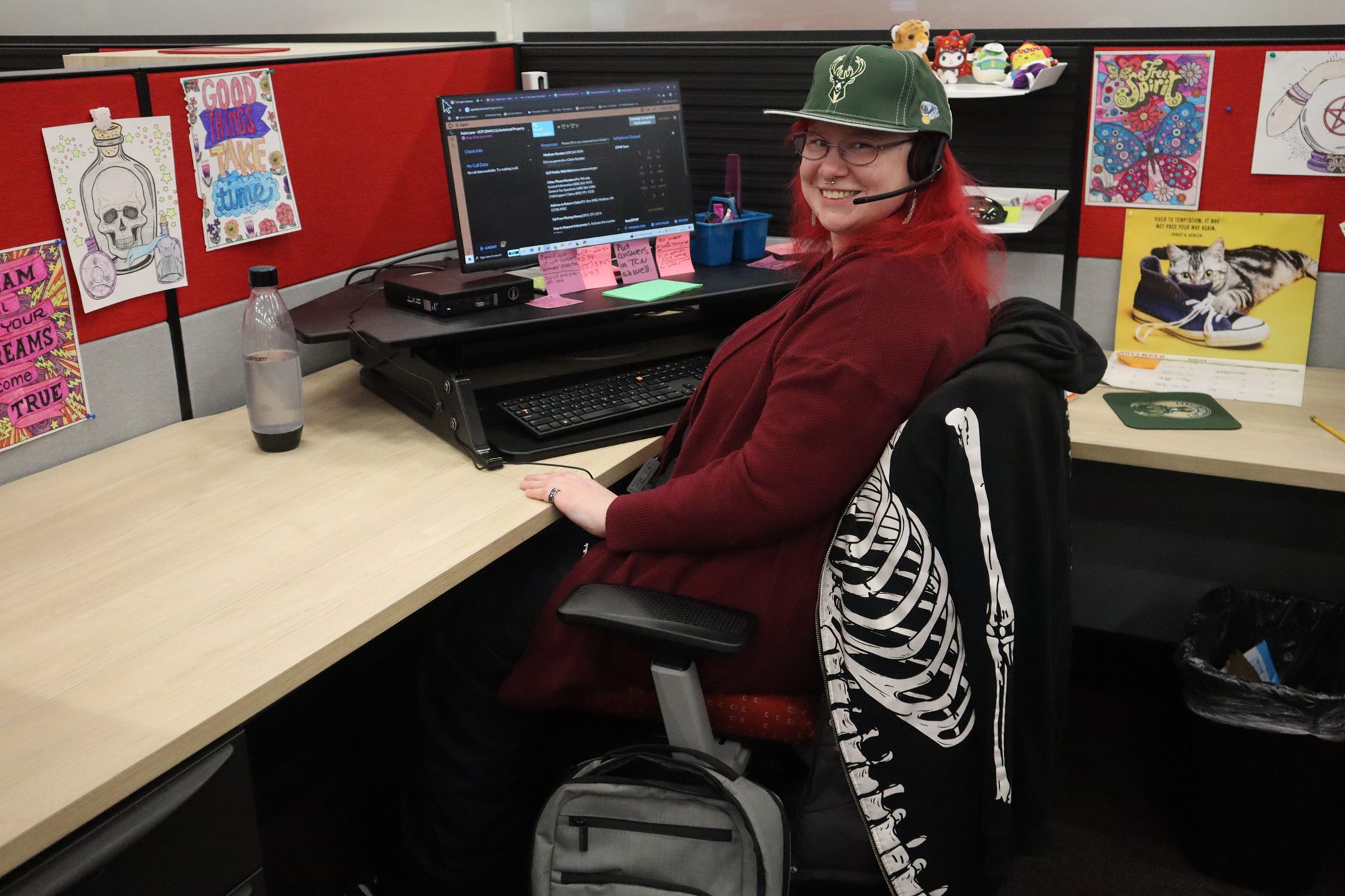 Katie Lone sitting at her desk and smiling at the viewer.