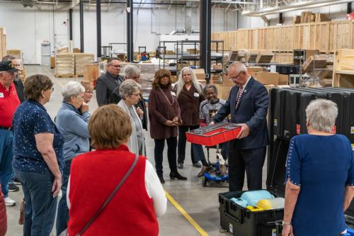 Veterans and their family members standing in our manufacturing area learning about the government kits we assemble.
